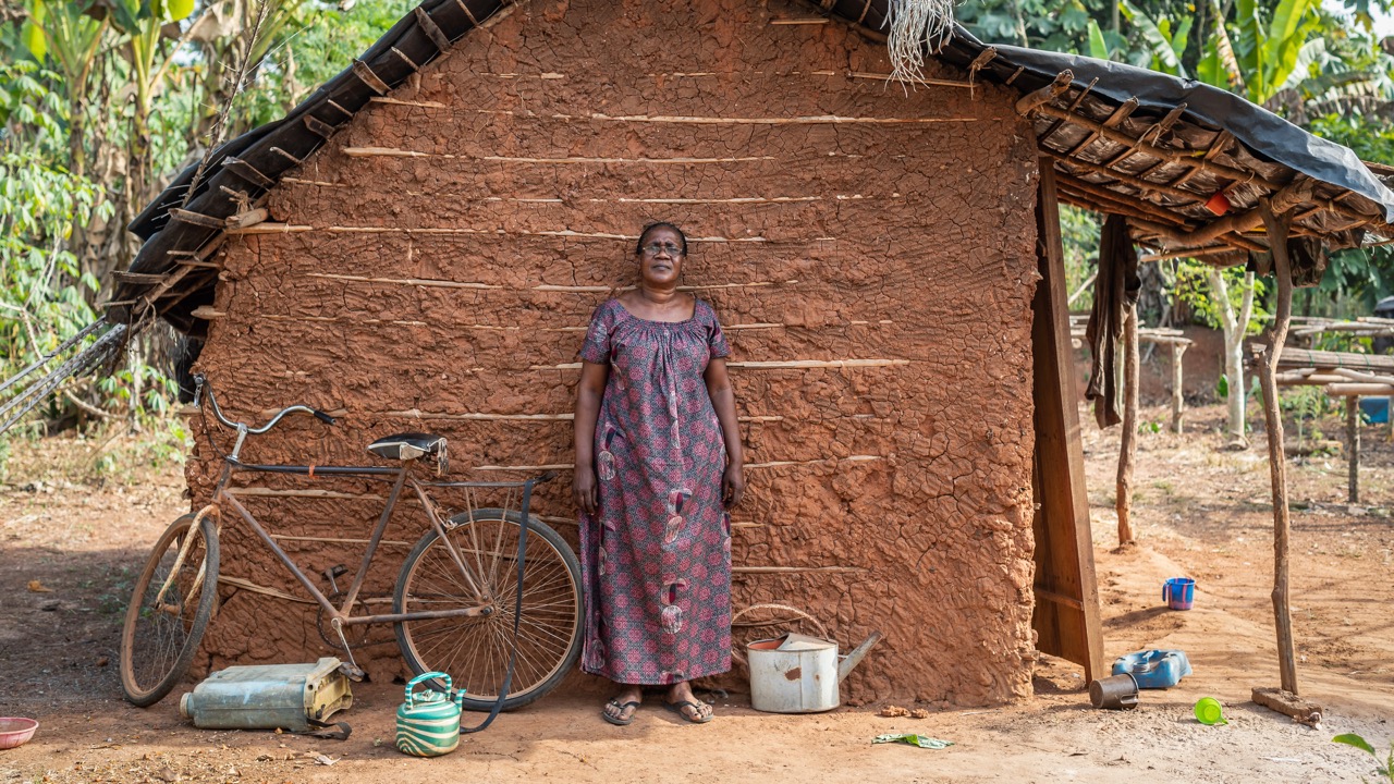 Amah standing outside a hut