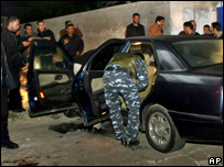 Policiais palestinos inspecionam o carro atingido por uma explosão em Gaza