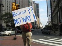 homem exibe cartaz com dizeres contra operação de resgate 