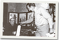 Dic Jones yn cyflwyno bat criced i T Llew Jones wedi ei lofnodi gan y beirdd a fu'n ei gyfarch.