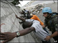 Soldado brasileiro da ONU revista suspeitos em Cité Soleil, na capital haitiana