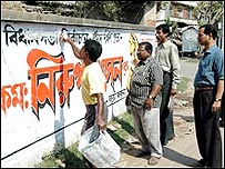 दीवारों पर से नारे मिटवाते अधिकारी