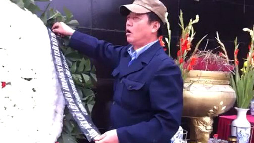 Một bảo vệ toan gỡ dòng chữ tưởng niệm những người ngã xuống trong cuộc chiến biên giới hôm 17/2/2013