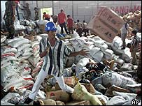 Trabalhador de equipe de ajuda separa caixas com mantimentos na Indonésia