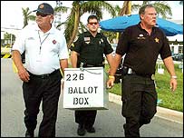 Bir seçim sandığını taşıyan görevliler