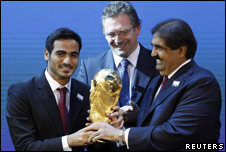 Members of Qatar's World Cup bid team celebrate with the World Cup trophy