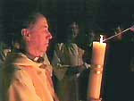 Minister carrying the large white Paschal candle