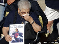 Một người tham gia lễ tưởng niệm cầm ảnh của người đứng đầu ban phòng cháy chữa cháy New York