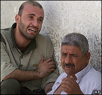 بستگان قربانيانی که در جشن عروسی کشته شدند، بيرون بيمارستانی در بغداد نشسته اند و می گريند