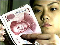 Chinês observa a moeda chinesa Yuan