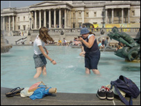 Jovens brincam dentro de fonte na Praça Trafalgar, Londres