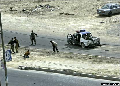 Warga Irak yang terkejut bereaksi beberapa saat setelah bom tepi jalan meledak mengincar patroli polisi pada ulangtahun ketiga invasi pimpinan Amerika