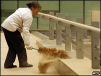 Chinesa limpa areia acumulada durante tempestade em Pequim