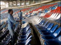 سٹیڈیم کی کرسیوں کو پانی سے صاف کیا جا رہا ہے