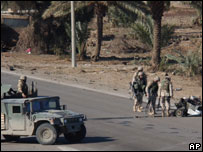 Soldados americanos examinam carro-bomba na estrada do aeroporto de Bagdá