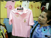 Một người dân Bangkok cầm chiếc áo phông hồng mà nhiều người mặc để ủng hộ vua Bhumibol Adulyadej