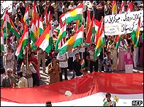 Demonstração com bandeiras curdas