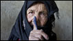 An elderly woman shows off her inked finger after she cast her vote in Afghanistan's elections in September 2010