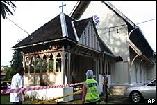 Police officers inspect damage at the All Saints Church in Taiping of Perak state, Malaysia