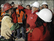 رئيس تشيلي(يمين) يحتضن ثاني عامل خرج من المنجم