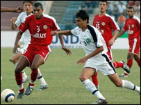 O uzbeque Anvarjon Saliev (esquerda) disputa a bola com Addulla Rahman Marzook