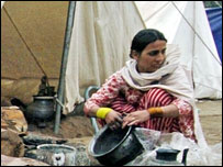   خیمے کے باہر برتن دھونے میں مصروف ایک خاتون