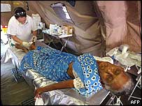 زن مسن در بيمارستان صحرايی تحت مداواست