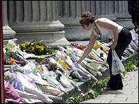 مردم در محل انفجار اتوبوس که به کشته شدن 13 نفر انجاميد شاخه های گل می گذارند