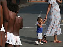 Menino e sua mãe passam em frente a meninas nuas que serão testadas
