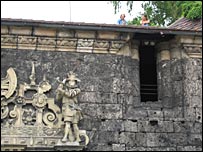 坐在古城堡城墙屋顶上的两位学生（见右上方）