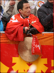 Một người đàn ông khua chiêng ở sân vận động Olympia