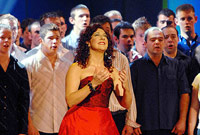 Shân Cothi yn perfformio gyda'r côr ar y llwyfan