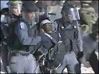 Colono judeu sendo levado de prédio por policiais israelenses