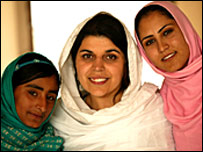 افغان فٹ بال کی ٹیم کے اراکین روئیہ نور احمد (بائیں) اور شاملہ کوہستانی (دائیں) ایک افغان اہلکار کے ساتھ