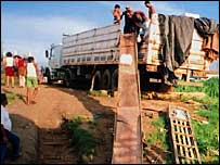 Homens descarregam mercadoria de caminhão