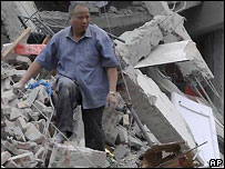 Homem anda sobre escombros