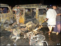 Policial ao lado de destroços de carro-bomba em Basra