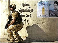 Irak'ta bir asker ve seçim posteri