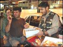 عضو بسيج هنگام توزيع شيرينی