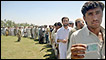 An internally displaced Pakistani man holds up an identity card as he waits in line for relief supplies at a UNHCR distribution point at a makeshift camp in Mardan on May 11, 2009