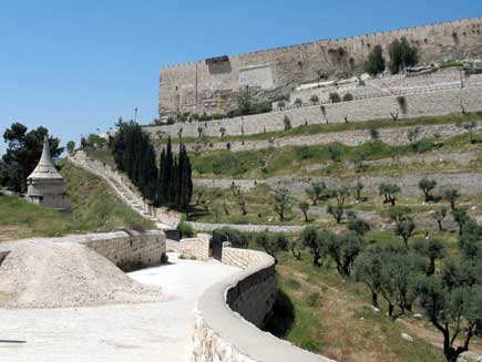 Absalom's tomb (left, middle distance), a small white building with conical roof, with Jerusalem's white city walls curving through the foreground and visible in the background