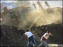 Palestinos jogam pedras em escavadeira israelense