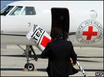 Membro da Cruz Vermelha se aproxima de avião que participa da operação de resgate