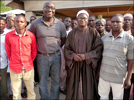 Komla Dumor with Chief Turaki Danladi Rabo, the two men chosen to receive the phones and a group of other male villagers