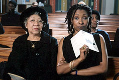 Image: Grandma Sylvia (Mona Hammond) makes daughter Natalie (Jo Martin) at a funeral. 