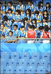 Estádio com voluntários ocupando lugares vazios
