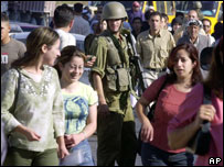 Palestinas passam por um posto de controle israelense ao entrar em Ramallah