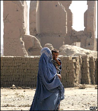 زن و کودک در برابر ساختمان های ويران