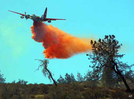 A plane drops water to put out a fire