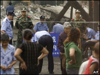Pais próximo à antiga escola, cercada por policiais